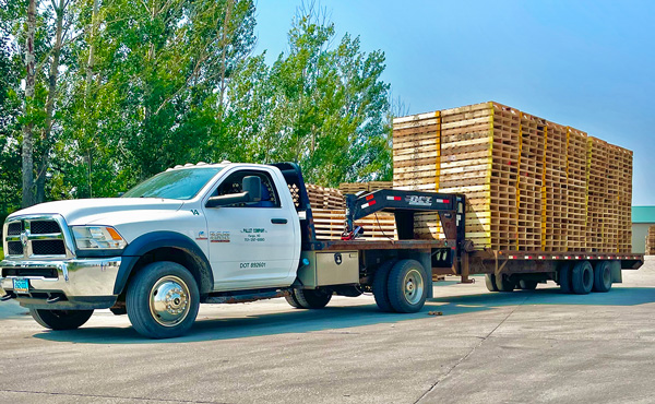 truck hauling pallets on a trailer | The Pallet Company - West Fargo, ND